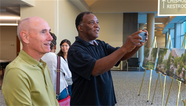 Two men looking at renderings of the future Barron's Branch Park
