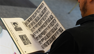 Closeup of a man looking at an old high school yearbook